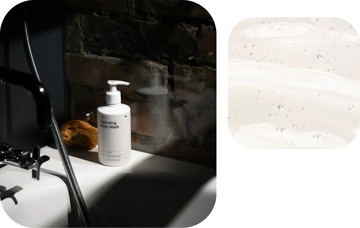 White bottle of body wash on a dark surface with a close-up of a textured white stone.